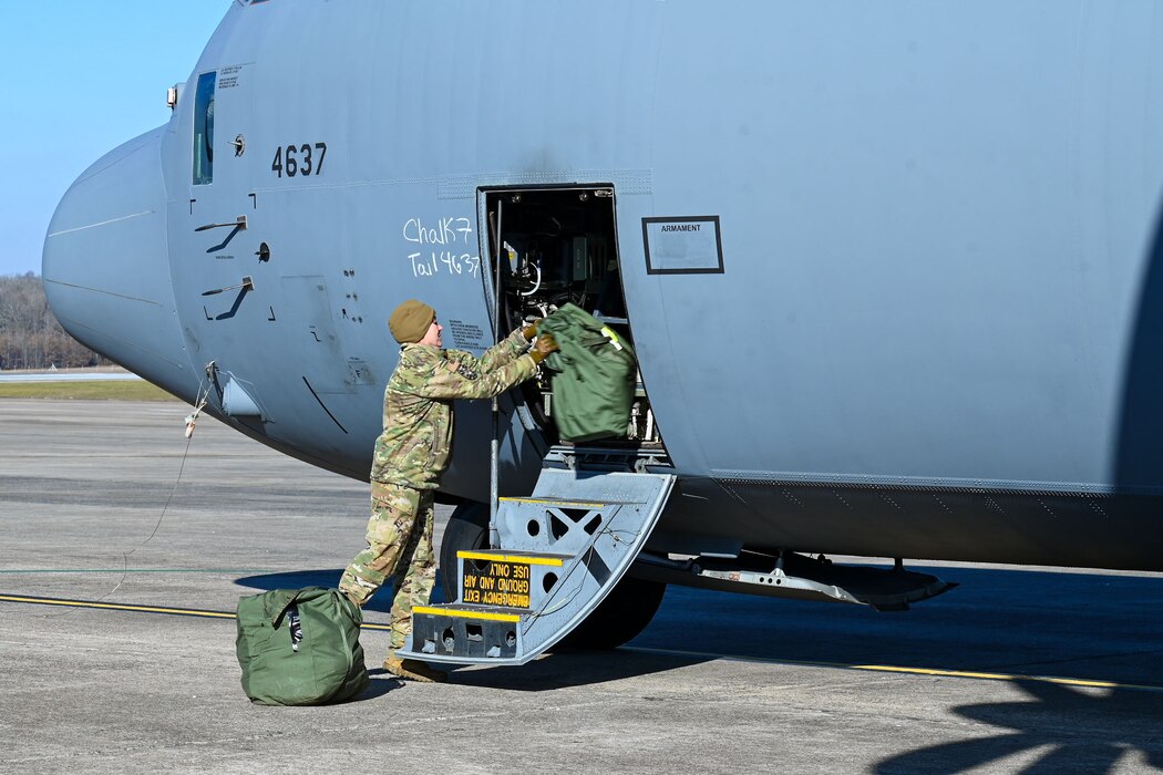 An Airman loads bags into a aircraft.