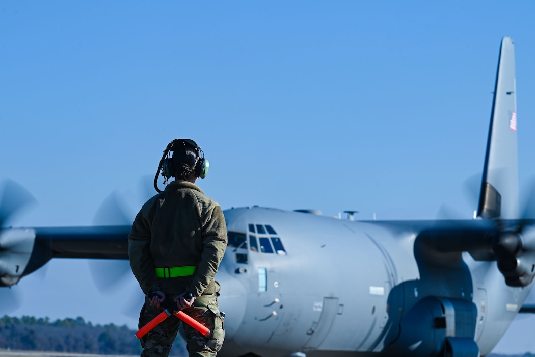 An Airman stands in front of a plane.