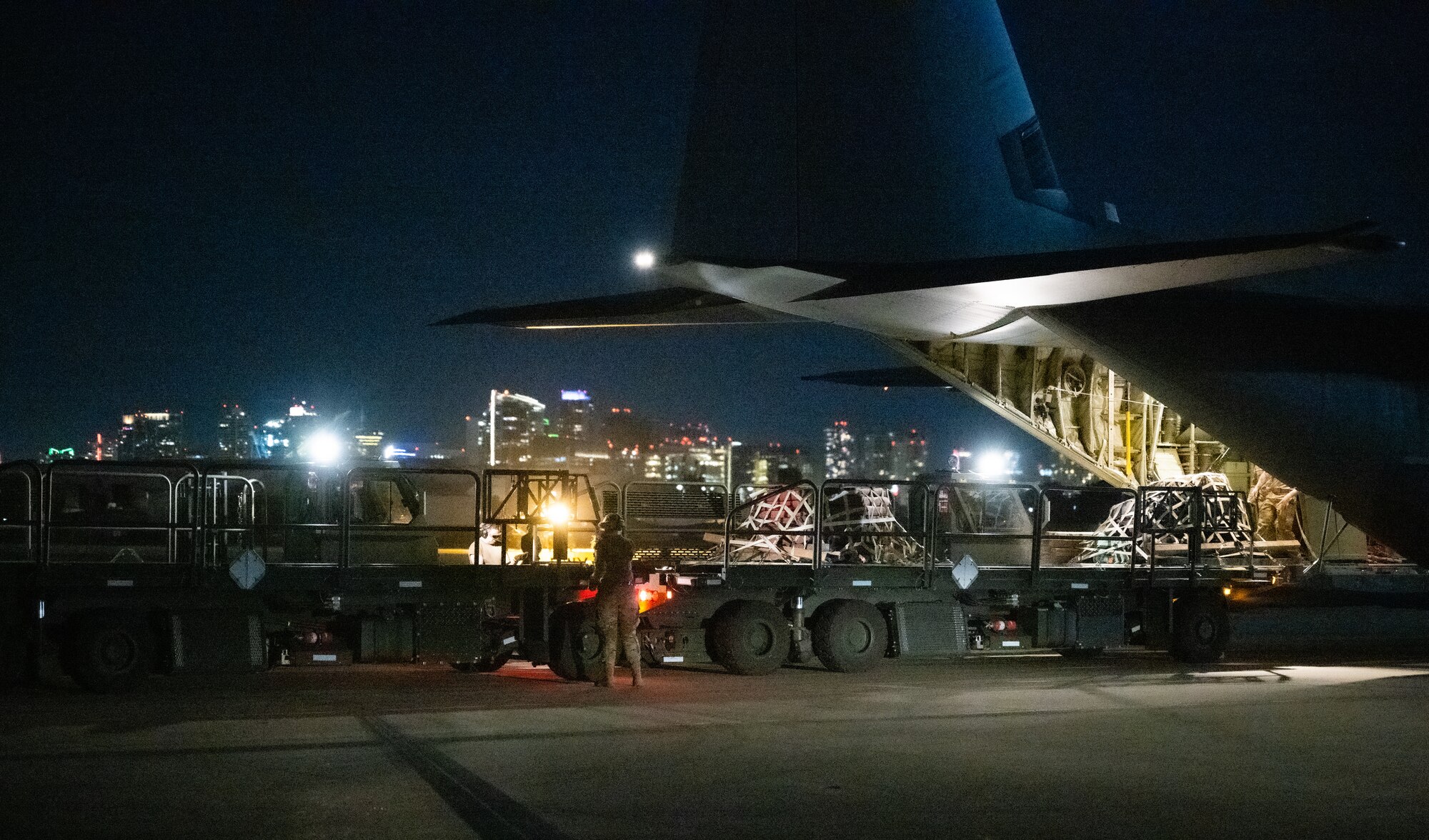 U.S. Air Force Senior Airman Alyssa Bradshaw, 732nd Expeditionary Air Mobility Squadron load team chief, deployed from Joint Base Elmendorf-Richardson, Alaska, directs cargo arrival from a C-130 Hercules during Exercise Bamboo Eagle 24-1 at Naval Air Station North Island, California, Jan. 26, 2024.