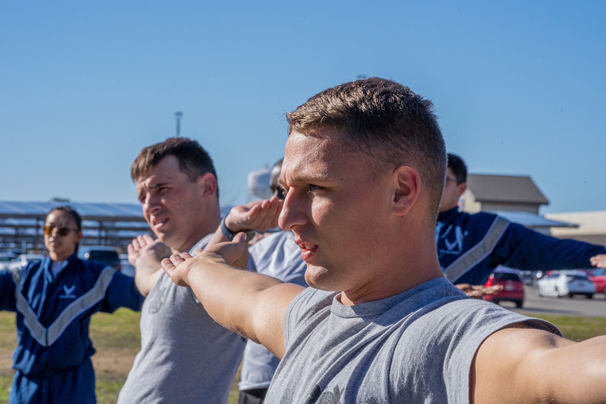 Coast Guard Petty Officer 3rd Class Nathaniel Hoppes, a machinery technician assigned to Coast Guard Cutter Axe, performs warm-ups during Airman Leadership School physical training at Keesler Air Force Base, Mississippi, Jan. 18, 2024.