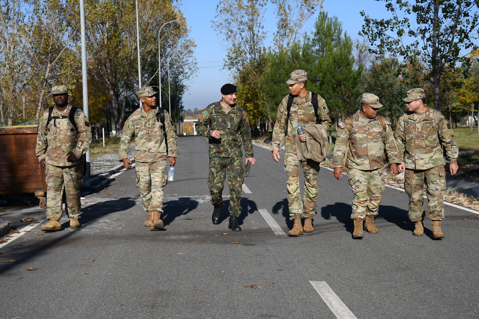U.S. Army Soldiers with the 254th Regimental Training Institute, New Jersey Army National Guard, walking and talking with Albanian Armed Forces Capt. Mirsit Bimaj, deputy company commander at Land Forces Headquarters.