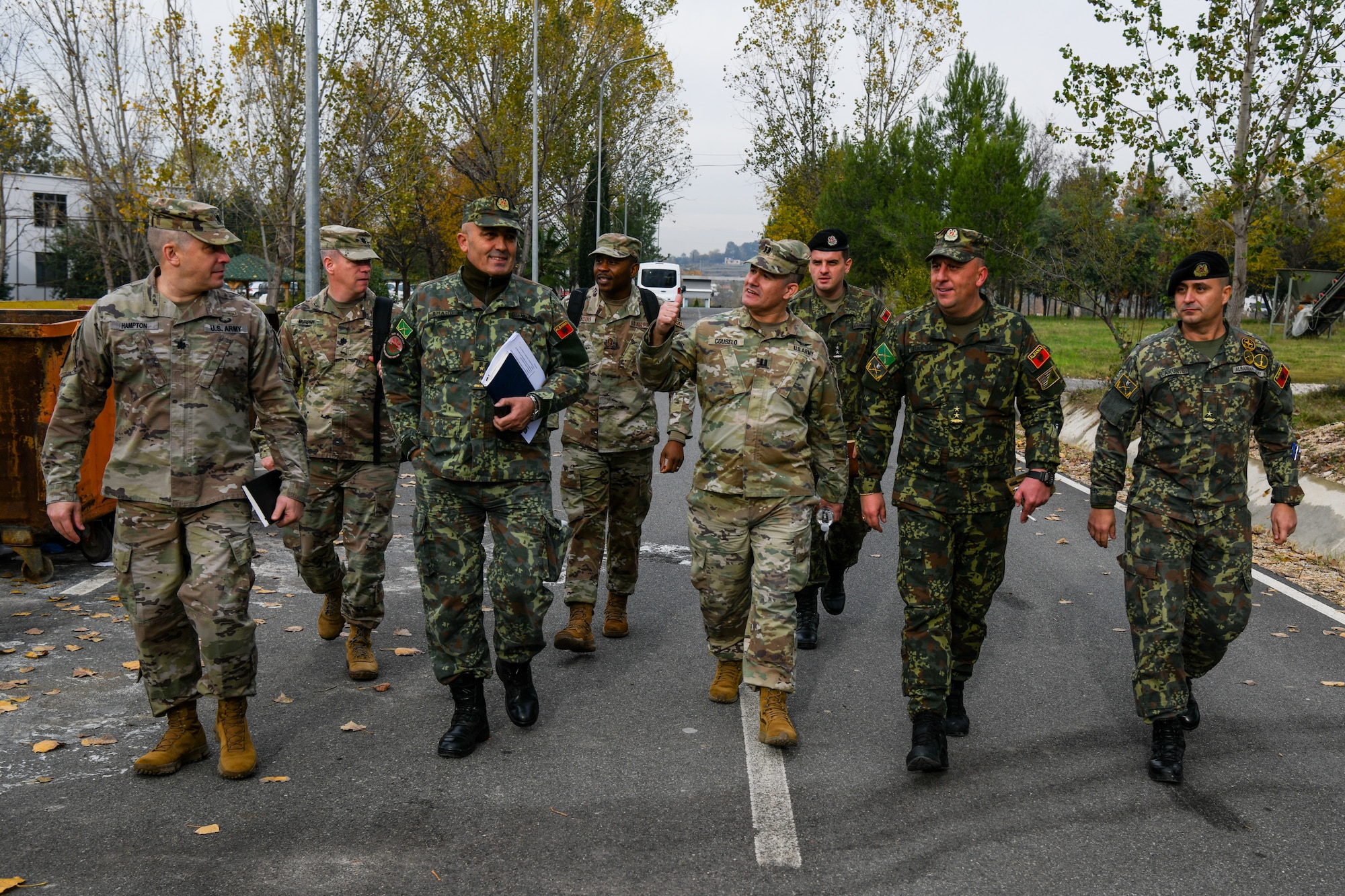 U.S. Air Force and Army service members walking and talking with Albanian Armed Forces at Land Forces Headquarters.