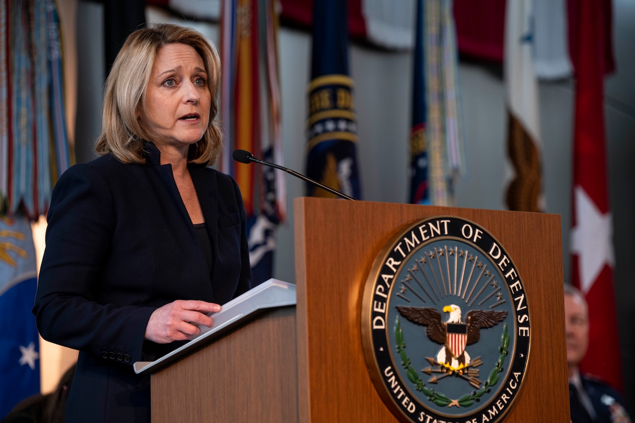 A woman speaks from a podium.