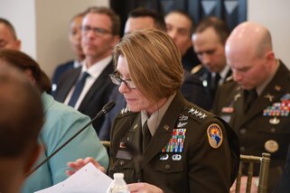 A military general looks down at papers during a meeting.