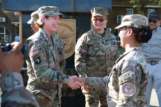 Military personnel shake hands.