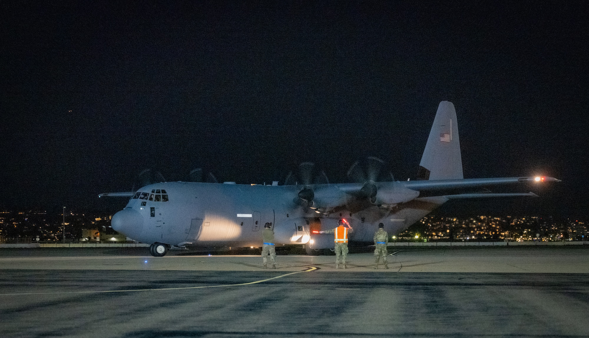 U.S. Air Force Senior Airman Kurt Rainey (center), a passenger service agent with the 732nd Expeditionary Air Mobility Squadron, deployed from Joint Base Elmendorf-Richardson, Alaska, exercises the Multi-Capable Airman concept by serving as a head marshaller for a C-130 departure during Exercise Bamboo Eagle 24-1 at Naval Air Station North Island, California, Jan. 26, 2024.