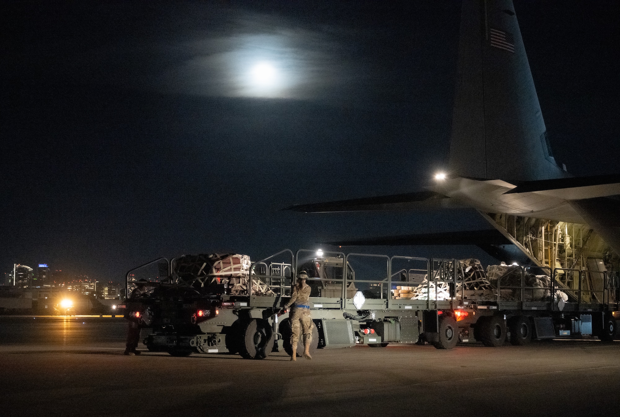 U.S. Air Force Senior Airman Alyssa Bradshaw, 732nd Expeditionary Air Mobility Squadron load team chief, deployed from Joint Base Elmendorf-Richardson, Alaska, directs cargo arrival from a C-130 Hercules during Exercise Bamboo Eagle 24-1 at Naval Air Station North Island, California, Jan. 26, 2024.