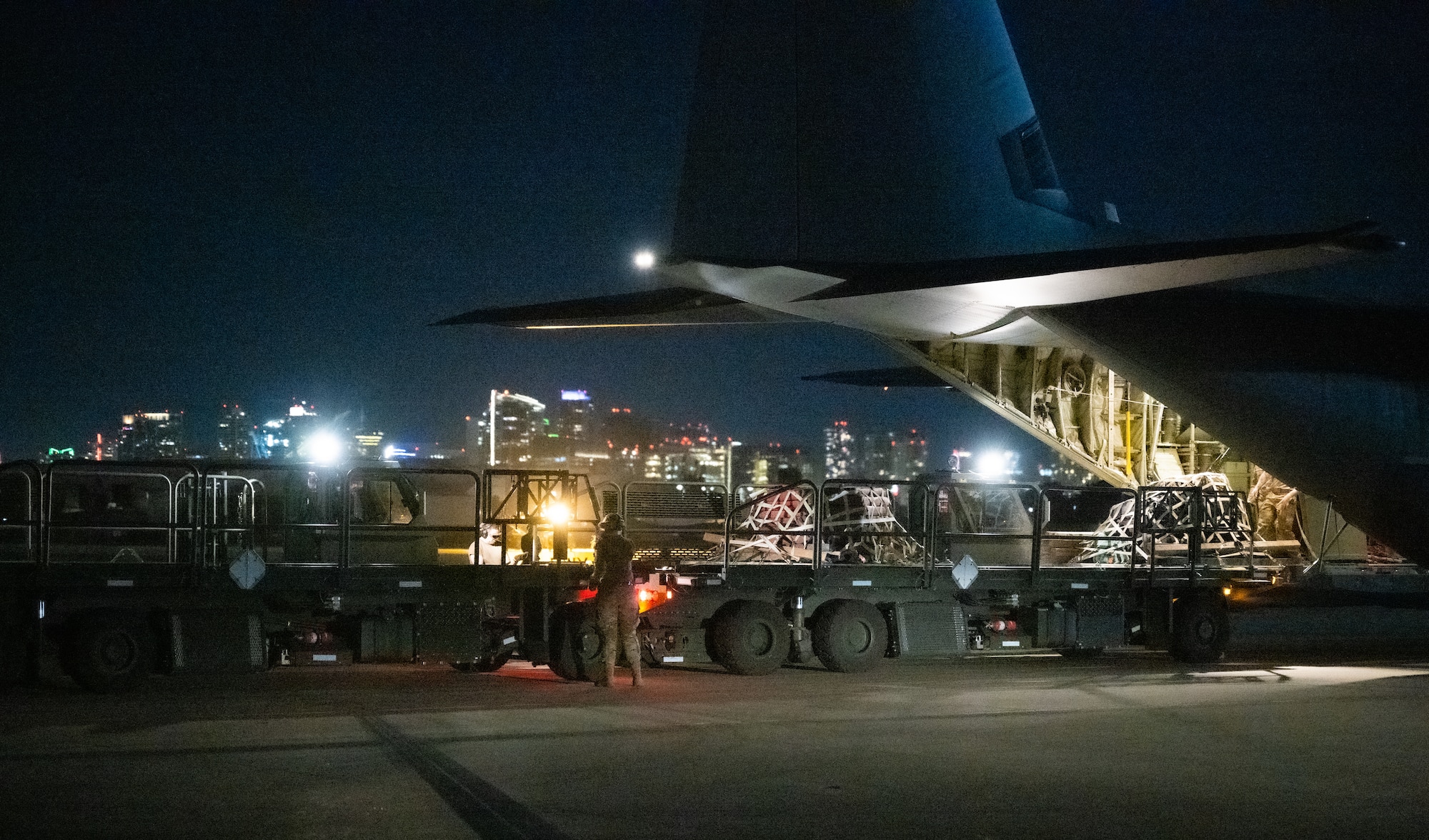 U.S. Air Force Senior Airman Alyssa Bradshaw, 732nd Expeditionary Air Mobility Squadron load team chief, deployed from Joint Base Elmendorf-Richardson, Alaska, directs cargo arrival from a C-130 Hercules during Exercise Bamboo Eagle 24-1 at Naval Air Station North Island, California, Jan. 26, 2024.