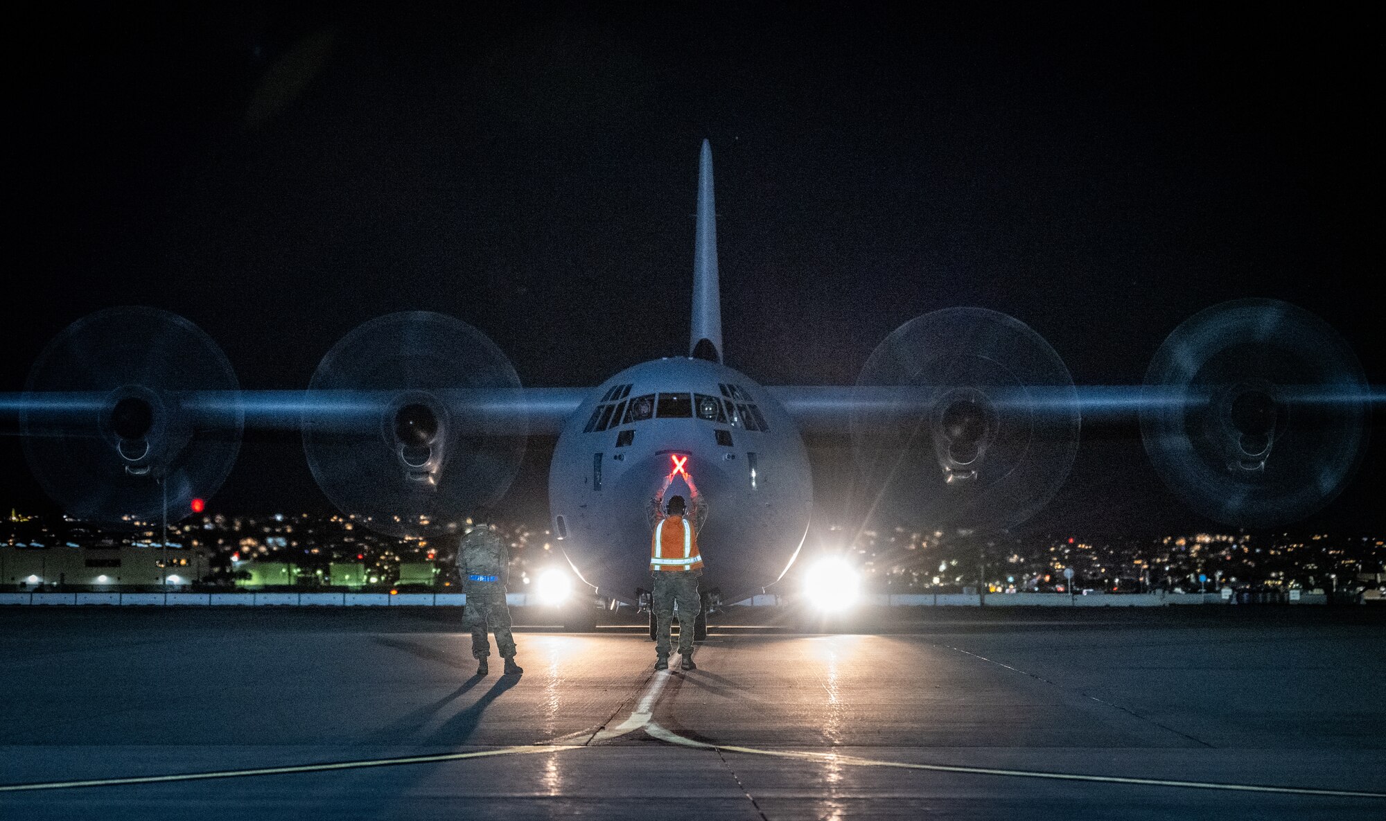 U.S. Air Force Senior Airman Kurt Rainey, a passenger service agent with the 732nd Expeditionary Air Mobility Squadron, deployed from Joint Base Elmendorf-Richardson, Alaska, exercises the Multi-Capable Airman concept by serving as a head marshaller for a C-130 arrival during Exercise Bamboo Eagle 24-1 at Naval Air Station North Island, California, Jan. 26, 2024.