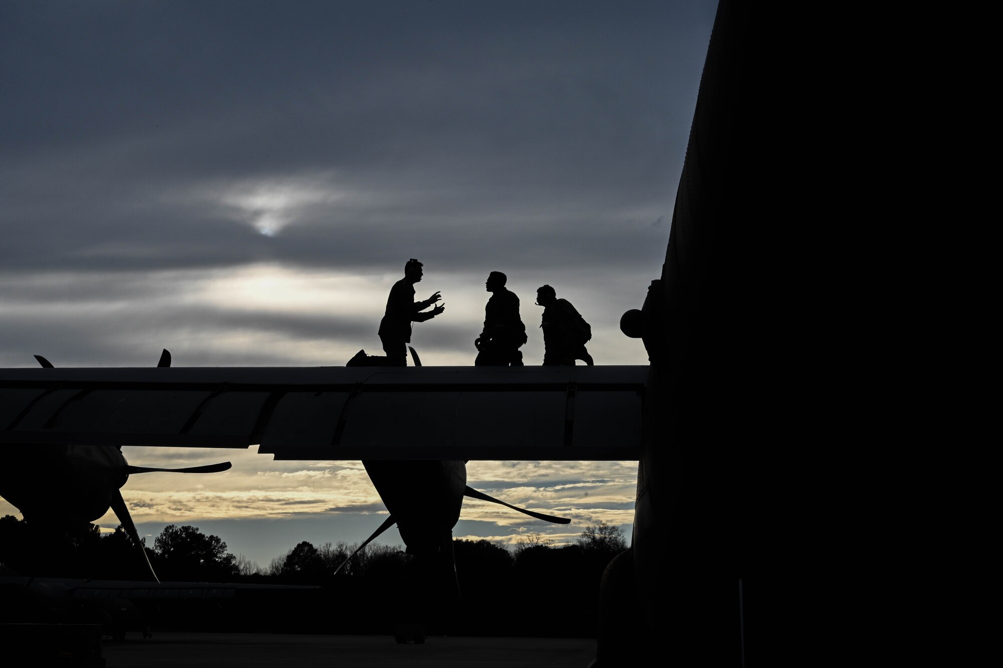 Airmen stand on a C-130.