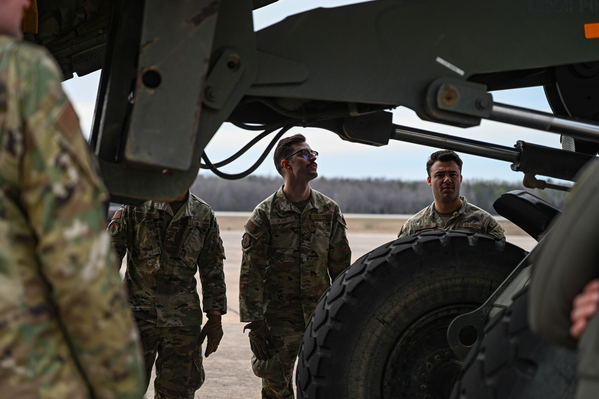 Airmen look at a forklift.