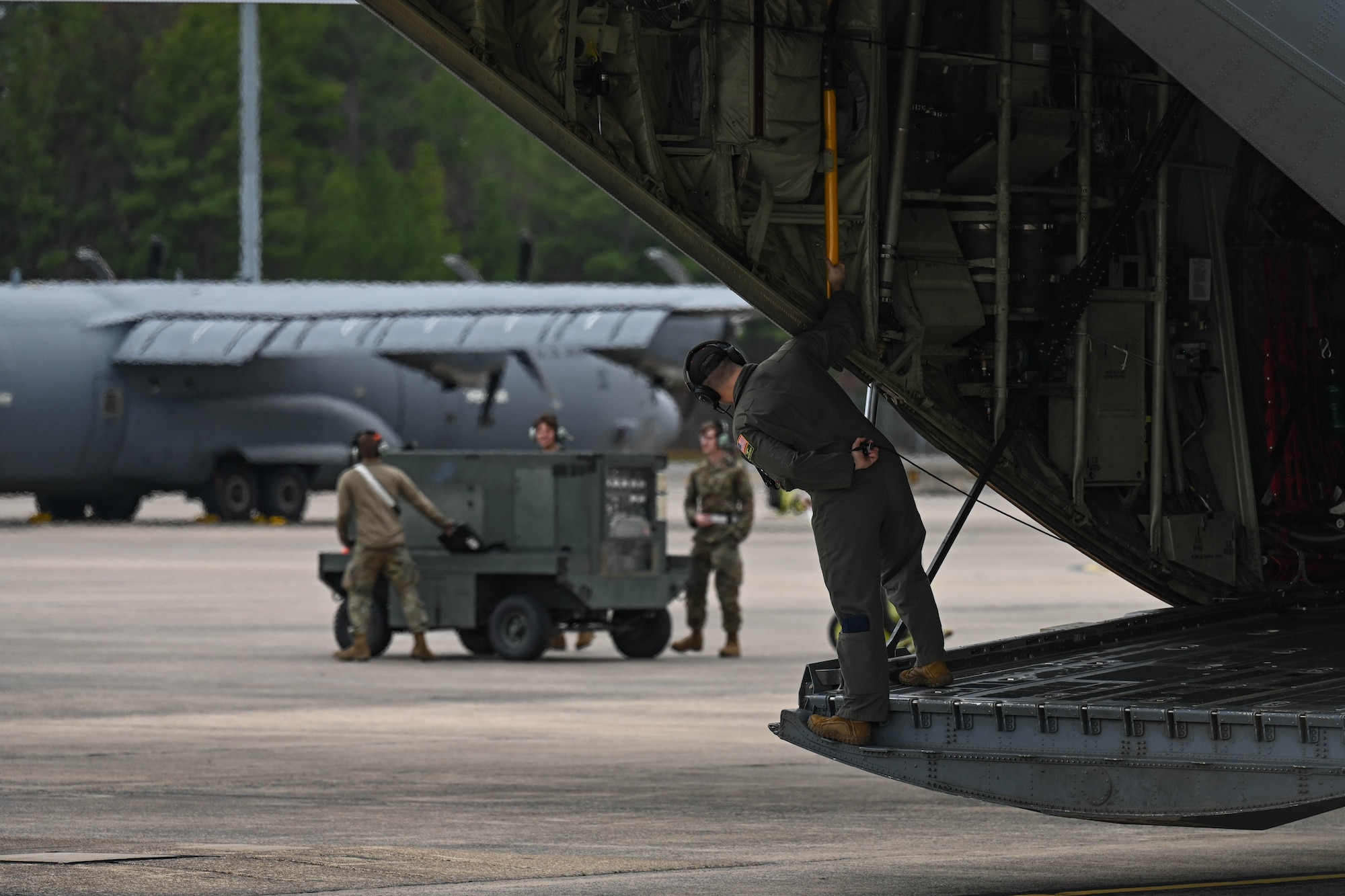 An Airman looks out the back of a C-130.