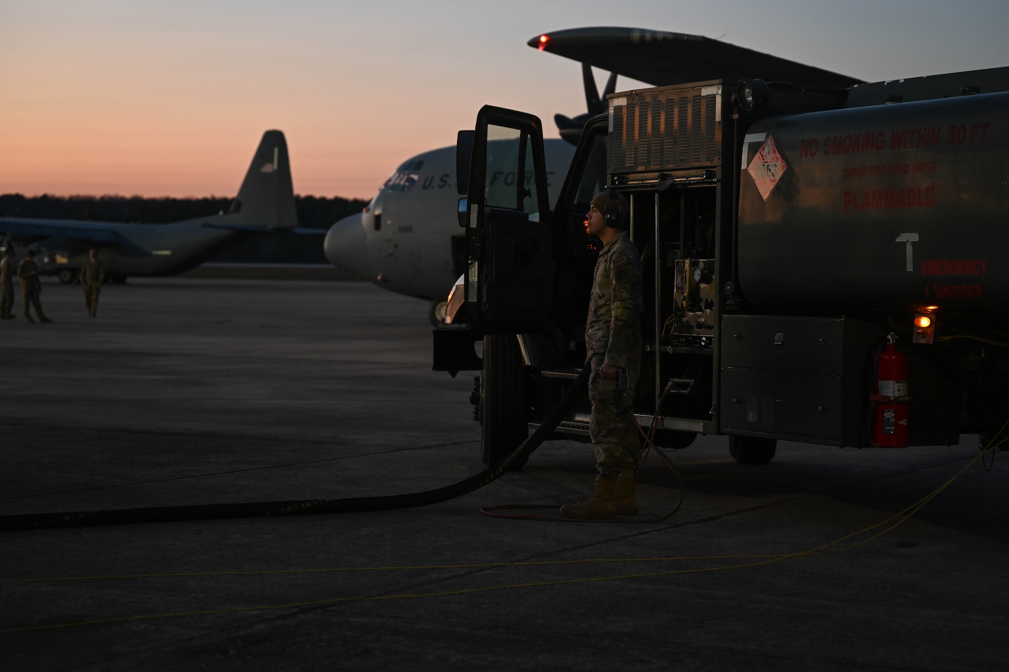An Airman stands next to a fuel truck.