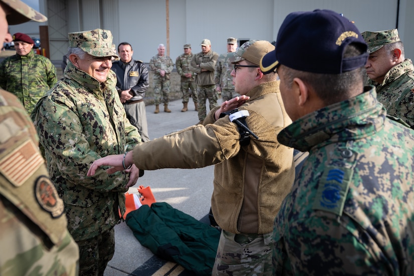 U.S. Air Force Senior Airman Elija Lamastus, right, a medic assigned the Kentucky Air National Guard’s 123rd Medical Group Detachment 1, demonstrates the use of a combat application tourniquet  to Ecuadorian Navy Adm. Jaime Patricio Vela Erazo, chief of staff of the Ecuadorian military, at the Kentucky Air National Guard Base in Louisville, Ky., Jan. 31, 2024. Vela Erazo is one of several Ecuadorian military leaders visiting this week to exchange information with the Kentucky National Guard as part of the State Partnership Program, a National Guard Bureau effort that pairs Guard units with foreign allies to foster enhanced understanding across all aspects of civil and military affairs. (U.S. Air National Guard photo by Dale Greer)