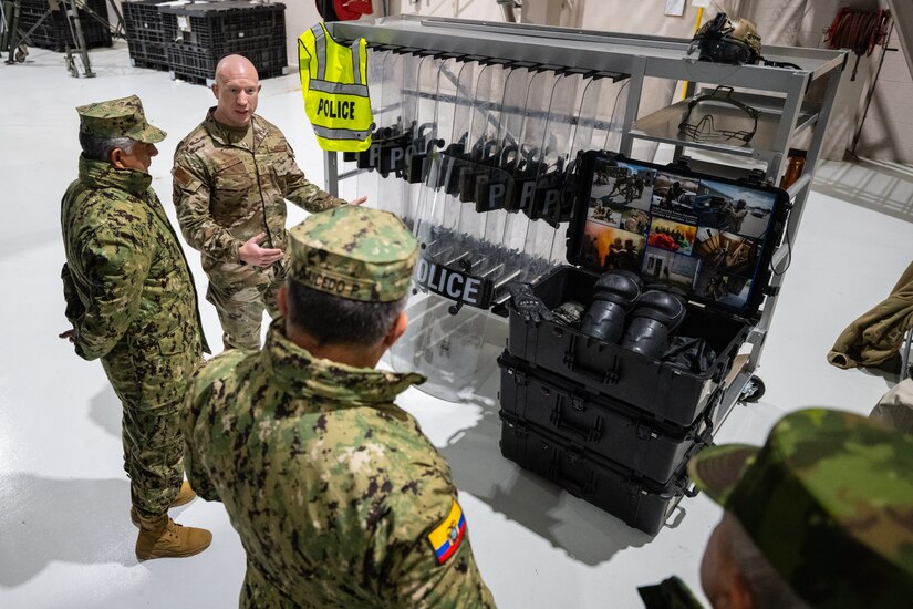 U.S. Air Force Master Sgt. Blake Nicholson, center, a security forces specialist assigned to the Kentucky Air National Guard’s 123rd Airlift Wing, discusses the use of civil disturbance protective equipment with Ecuadorian military leaders at the Kentucky Air National Guard Base in Louisville, Ky., Jan. 31, 2024. The Ecuadorians are visiting this week to exchange information with the Kentucky National Guard as part of the State Partnership Program, a National Guard Bureau effort that pairs Guard units with foreign allies to foster enhanced understanding across all aspects of civil and military affairs. (U.S. Air National Guard photo by Dale Greer)