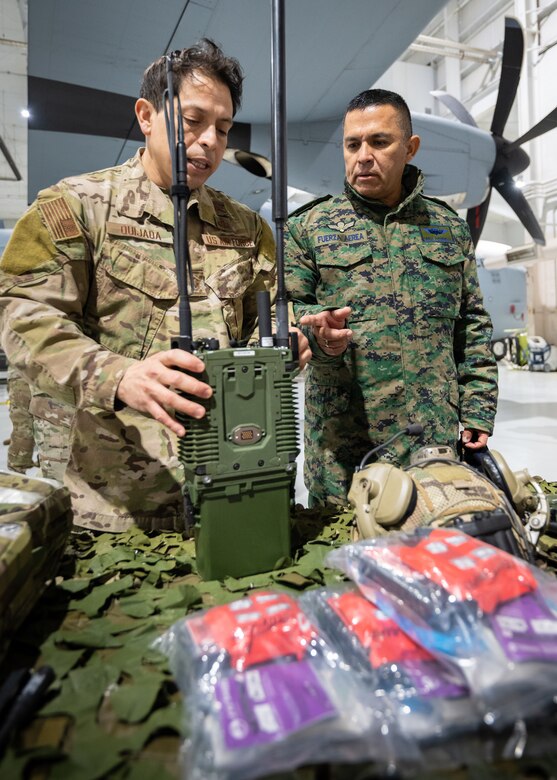 U.S. Air Force Master Sgt. Elmer Quijada, left, a pararescueman assigned to the Kentucky Air National Guard’s 123rd Special Tactics Squadron, discusses the unit’s radio equipment with Ecuadorian Air Force Chief Master Sgt. Carlos Humberto Rodriguez Castillo at the Kentucky Air National Guard Base in Louisville, Ky., Jan. 31, 2024. A group of Ecuadorian military leaders are visiting this week to exchange information with the Kentucky National Guard as part of the State Partnership Program, a National Guard Bureau effort that pairs Guard units with foreign allies to foster enhanced understanding across all aspects of civil and military affairs. (U.S. Air National Guard photo by Dale Greer)