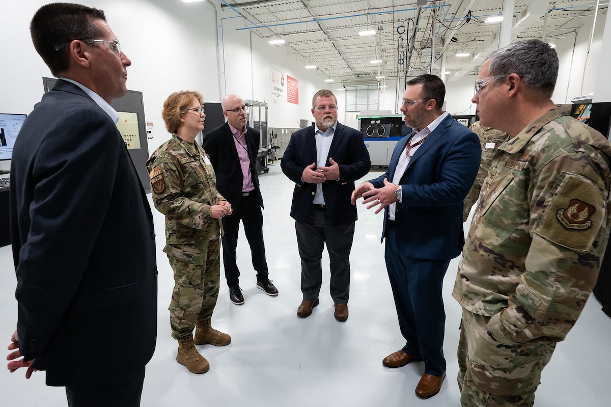 Group of men and one female Lt Gen standing and talking.
