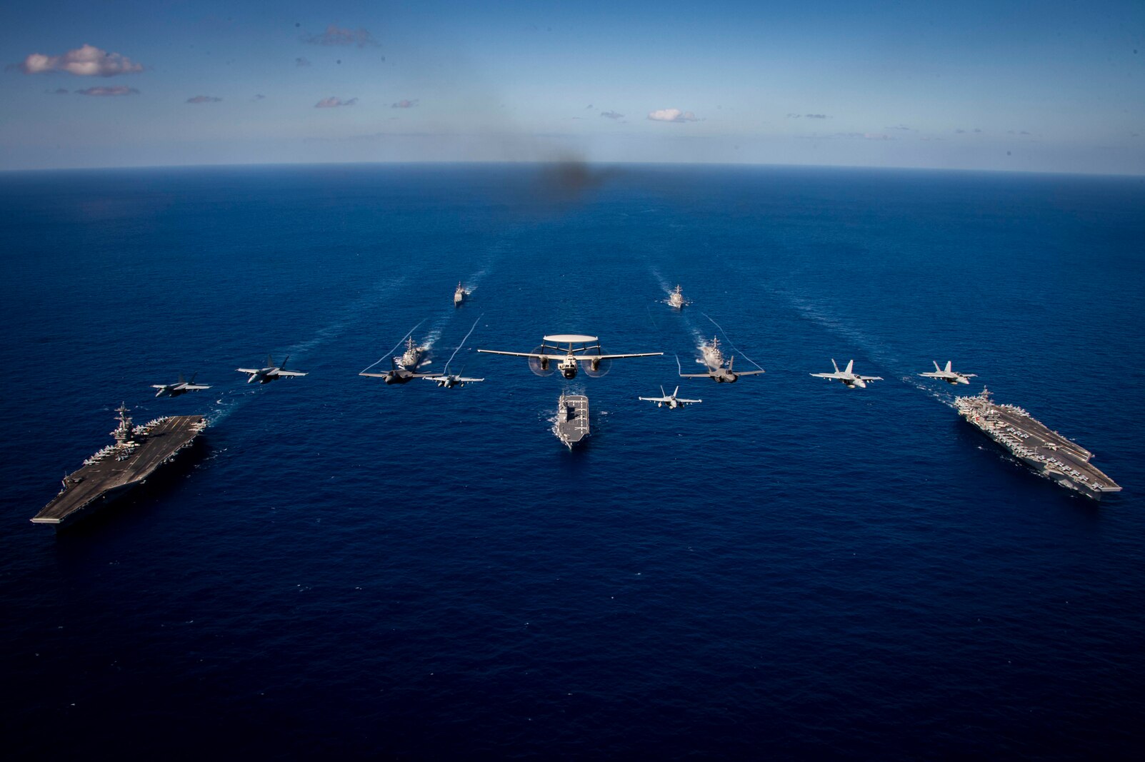 From left to right, Nimitz-class aircraft carrier USS Carl Vinson (CVN 70), Arleigh Burke-class guided-missile destroyer USS Sterett (DDG 104), Ticonderoga-class guided-missile cruiser USS Princeton (CG 59), Hyuga-class helicopter destroyer JS Ise (DDH 182), Arleigh Burke-class guided-missile destroyer USS Rafael Peralta (DDG 115), Arleigh Burke-class guided-missile destroyer USS Daniel K. Inouye (DDG 118), Nimitz-class aircraft carrier USS Theodore Roosevelt (CVN 71) along with aircraft assigned to Carrier Air Wing Two sail and fly in formation during Multi-Large Deck Event (MLDE)