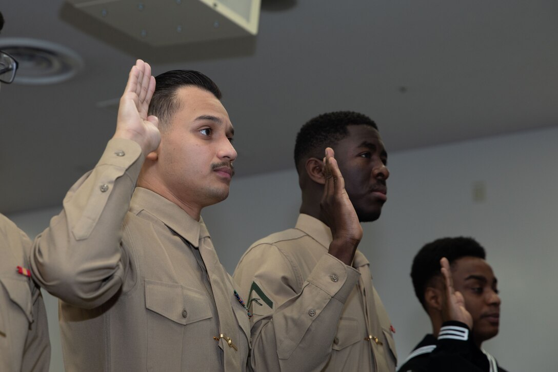 From left to right, U.S. Marine Corps Cpl. Jeferson HernandezEscobar, a motor vehicle operator with Combat Logistics Company 36, Combat Logistics Regiment 37, Lance Cpl. Cyrus Fayiah, an electrician with Marine Wing Support Squadron 171, Marine Aircraft Group 12, and U.S. Navy Aviation Mechanic Seaman Alwayne Cowie, assigned to Strike Fighter Squadron (VFA) 27, Carrier Air Wing (CVW) 5, swear in during a naturalization ceremony at Marine Corps Air Station Iwakuni, Japan, Jan. 30, 2024. The naturalization ceremony was held to acknowledge MCAS Iwakuni service members’ becoming citizens of the United States. The ceremony included service members from El Salvador, Liberia, Mexico, Jamaica, and the Philippines. (U.S. Marine Corps photo by Lance Cpl Colin Thibault)