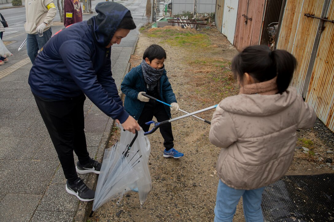 U.S. Sailors with the Marine Corps Air Station Iwakuni Chief Petty Officer Association and local Iwakuni residents participate in a trash clean-up competition as part of a community relations event in Iwakuni, Japan, Jan. 19, 2024. Community events such as this trash cleanup helps to build camaraderie through friendly competition, while being a positive force in the local area. (U.S. Marine Corps Photos by Lance Cpl. Dahkareo Pritchett)