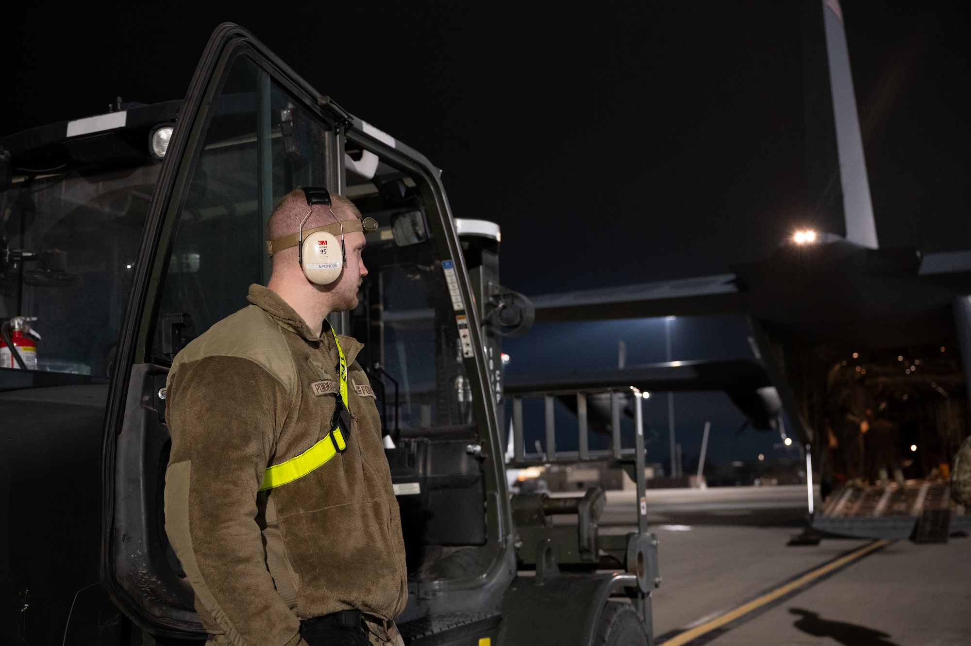 U.S. Air Force Airman 1st Class Nikita Ponomarenko, 515th Air Mobility Element air freight technician, waits for orders before helping load supplies on a C-130J Super Hercules at Nellis Air Force Base, Nevada, Jan. 25, 2024.