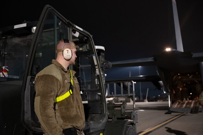 U.S. Air Force Airman 1st Class Nikita Ponomarenko, 515th Air Mobility Element air freight technician, waits for orders before helping load supplies on a C-130J Super Hercules at Nellis Air Force Base, Nevada, Jan. 25, 2024.