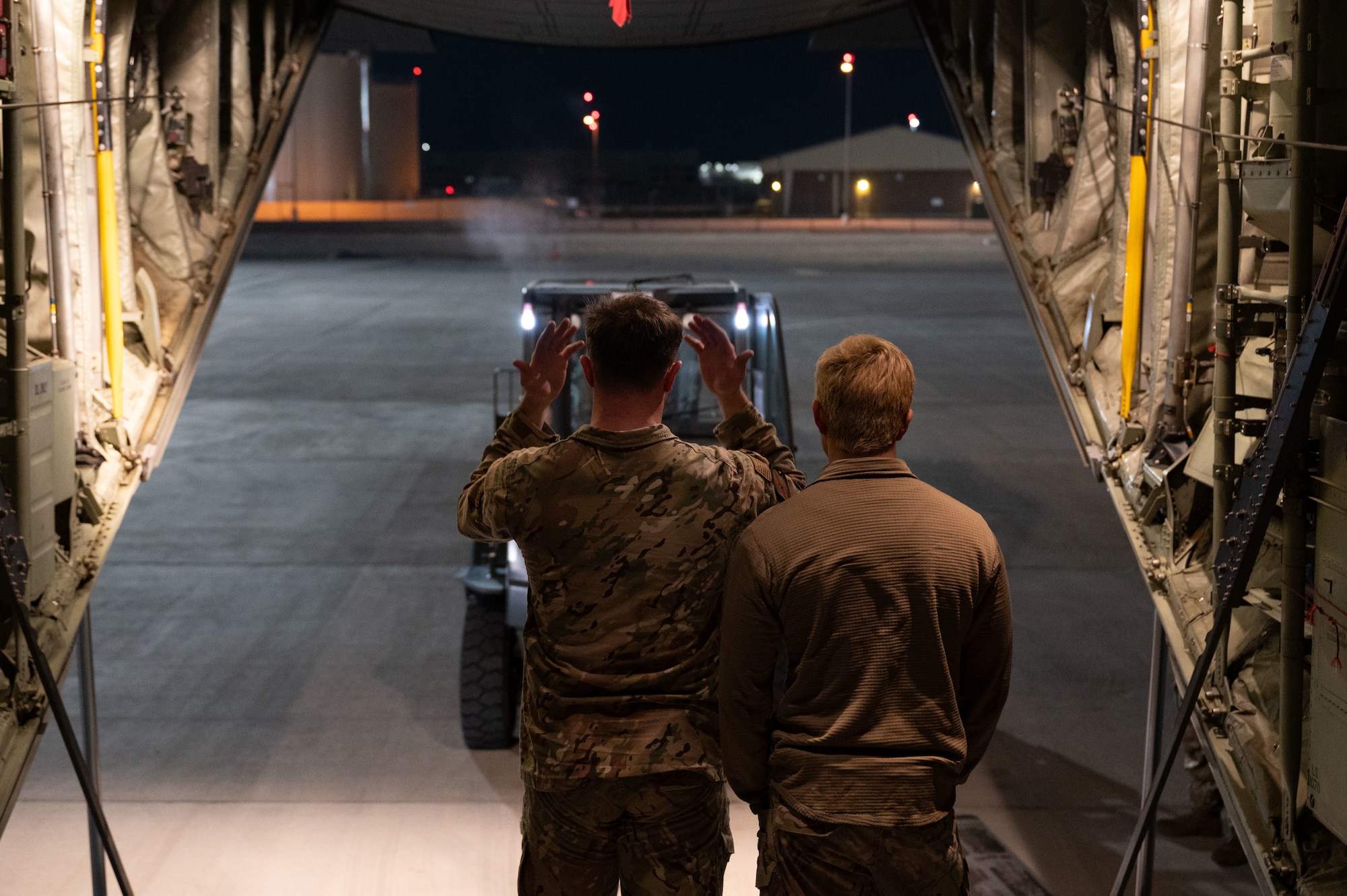 U.S. Air Force Airman 1st First Class Dylan Brown, left, and Senior Airman Adam Tristram, C-130J loadmasters assigned to the 40th Airlift Squadron at Dyess Air Force Base, Texas, guide a forklift on to a C-130J Super Hercules during Bamboo Eagle 24-1 at Nellis Air Force Base, Nevada, Jan. 25, 2024.