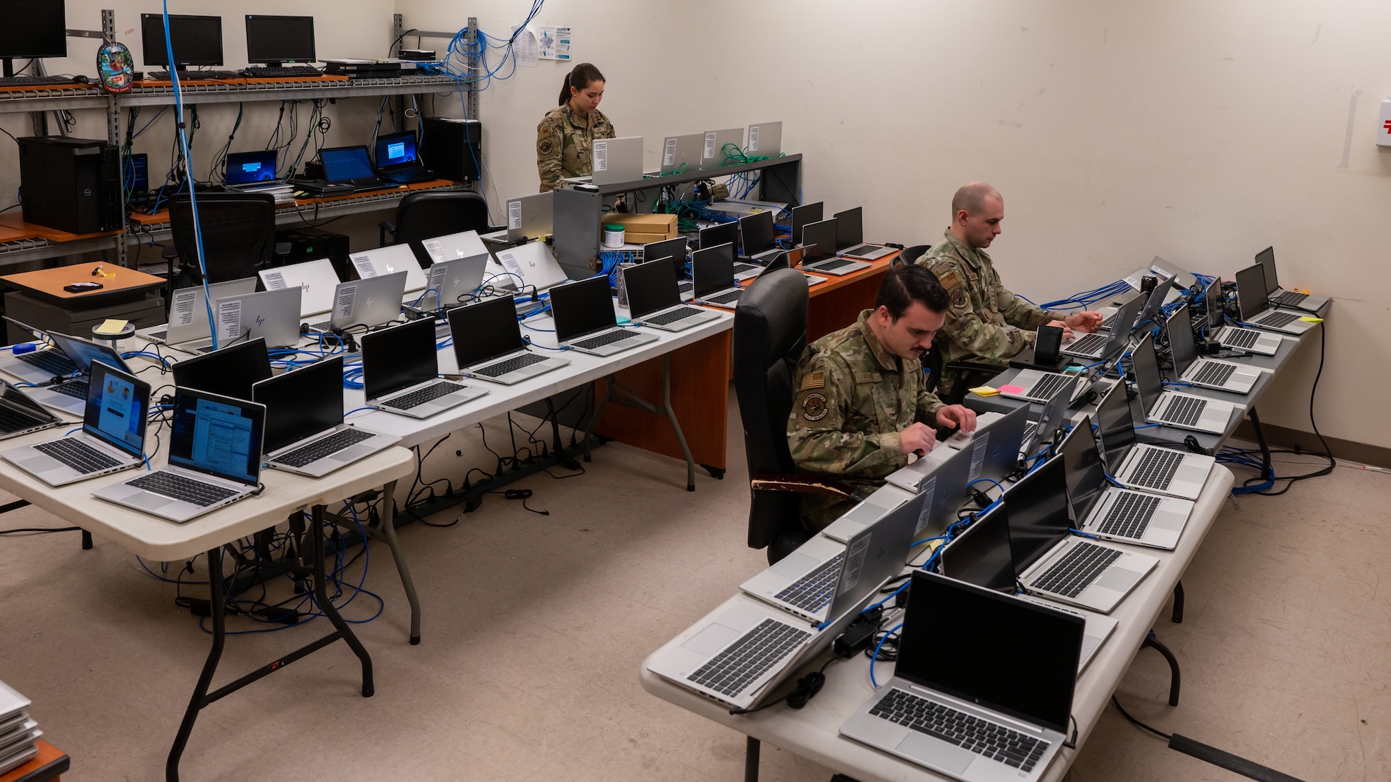 From left, Staff Sgt. Samantha Shupe, irman 1st Class Kenzer Lebret and Staff Sgt. Durham install programs on new computers