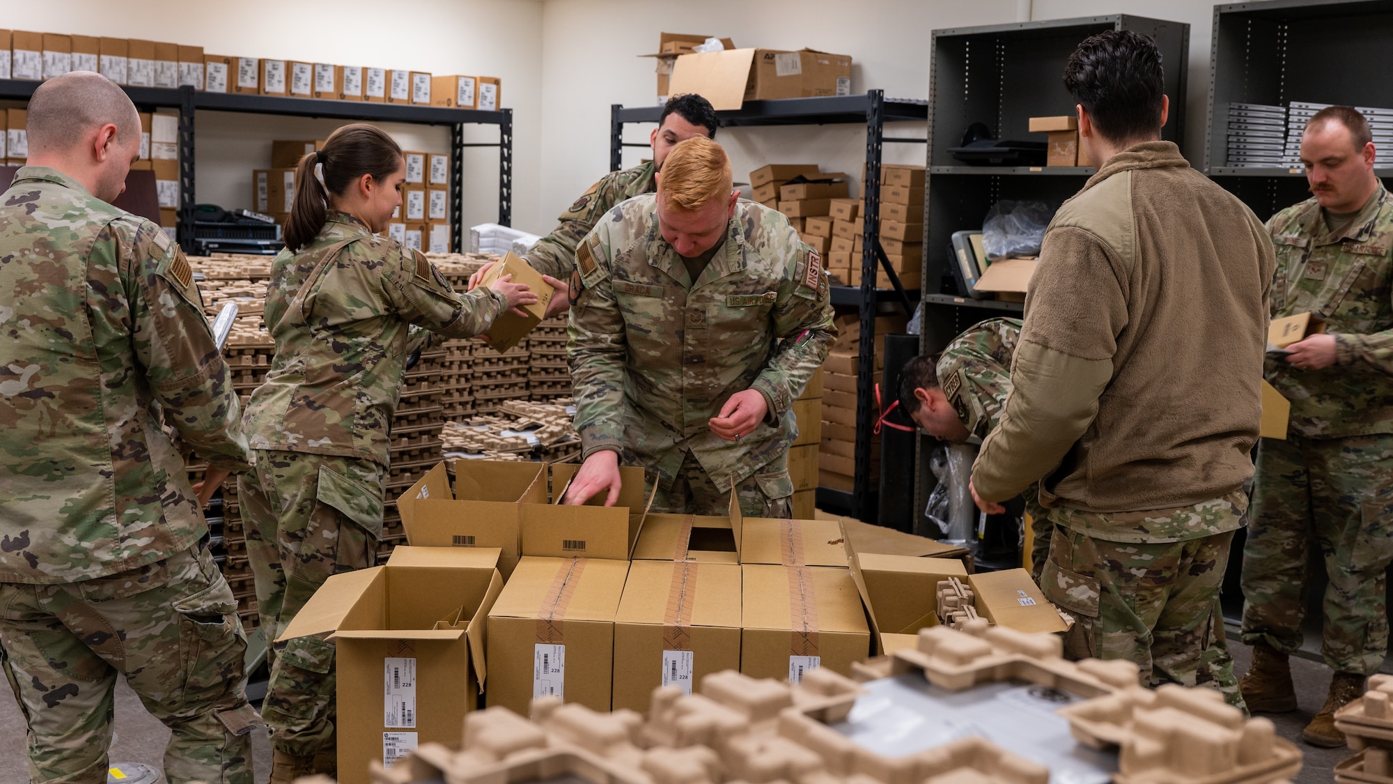 Airmen of the 8th Communications Squadron unpack a new inventory of laptops.