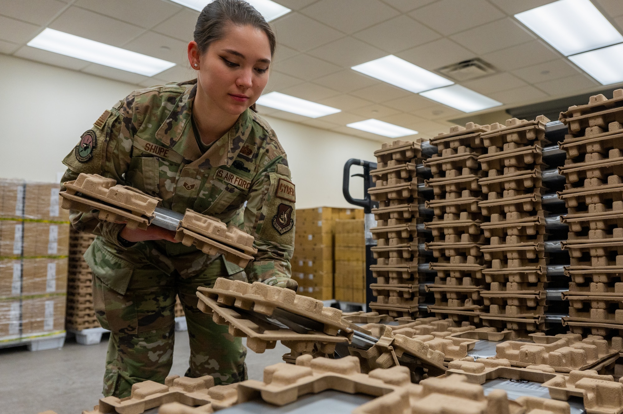 Staff Sgt. Samantha Shupe collects laptops from the 8th Communications Squadron storage room.