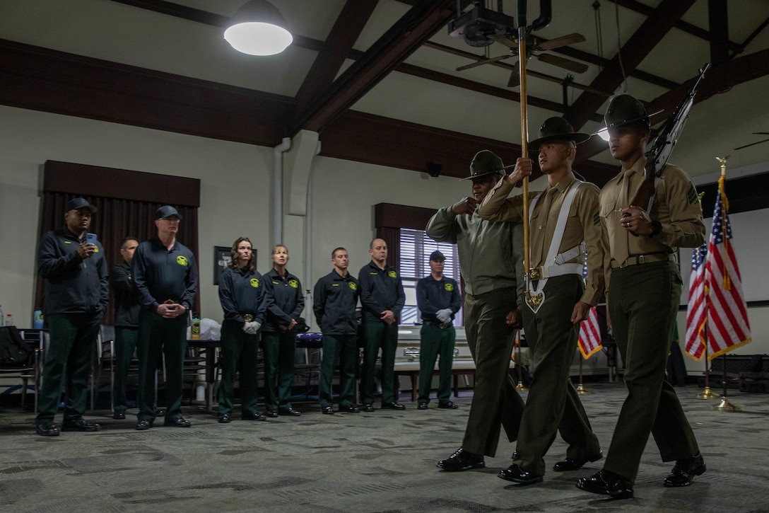 Members of the Marine Corps Recruit Depot San Diego Regiment Color Guard, demonstrate color guard techniques to members of the United States Forest Service Honor Guard at MCRD San Diego, Feb. 1, 2024. The USFS Honor Guard visited the Depot to promote and reinforce the customs, history, and traditions of the Marine Corps. (U.S. Marine Corps photo by Lance Cpl. Sarah M. Grawcock)