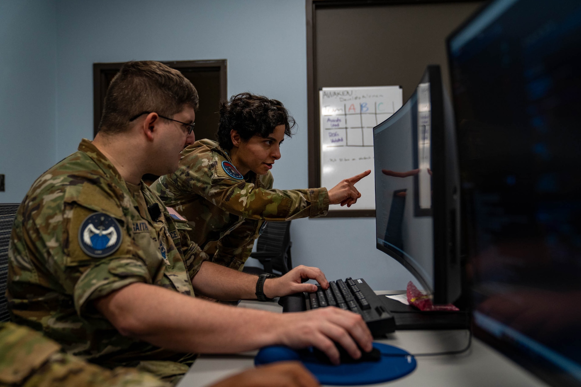 U.S. Space Force Sgt. Anastacia Lange, 333rd Training Squadron Cyber Warfare Operator course instructor, teaches Master Sgt. Stephen Gaiter, 333rd TRS student, how to run commands in Linux Operating Systems at Stennis Hall on Keesler Air Force Base, Mississippi, Jan. 24, 2024.