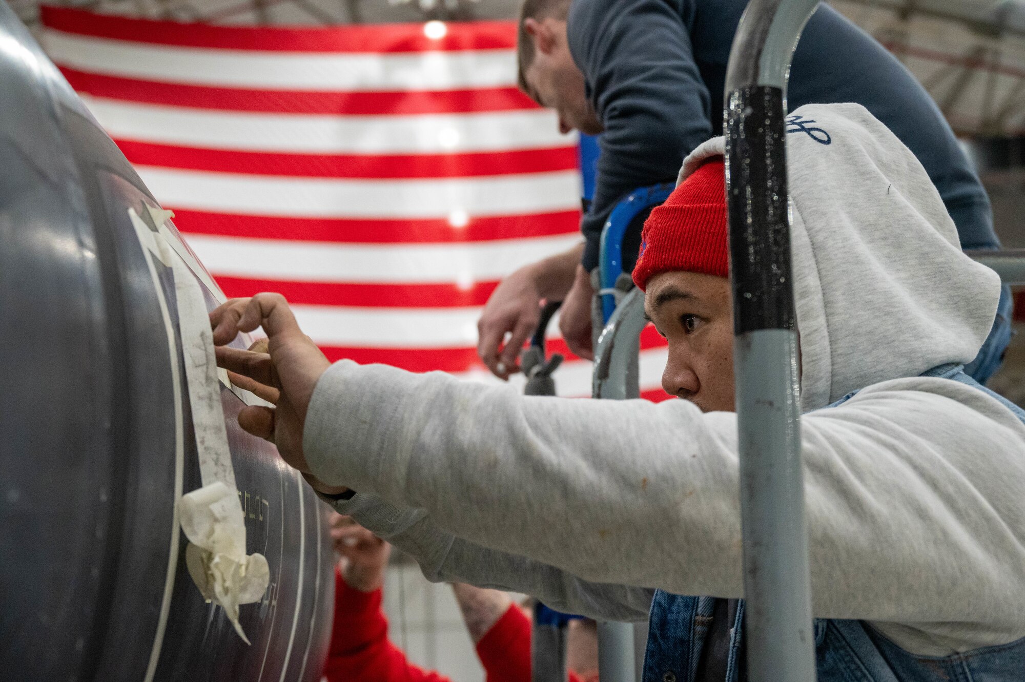 Airmen from the 99th Expeditionary Reconnaissance Squadron participate in a memorial drawing on a U-2 Dragon Lady.