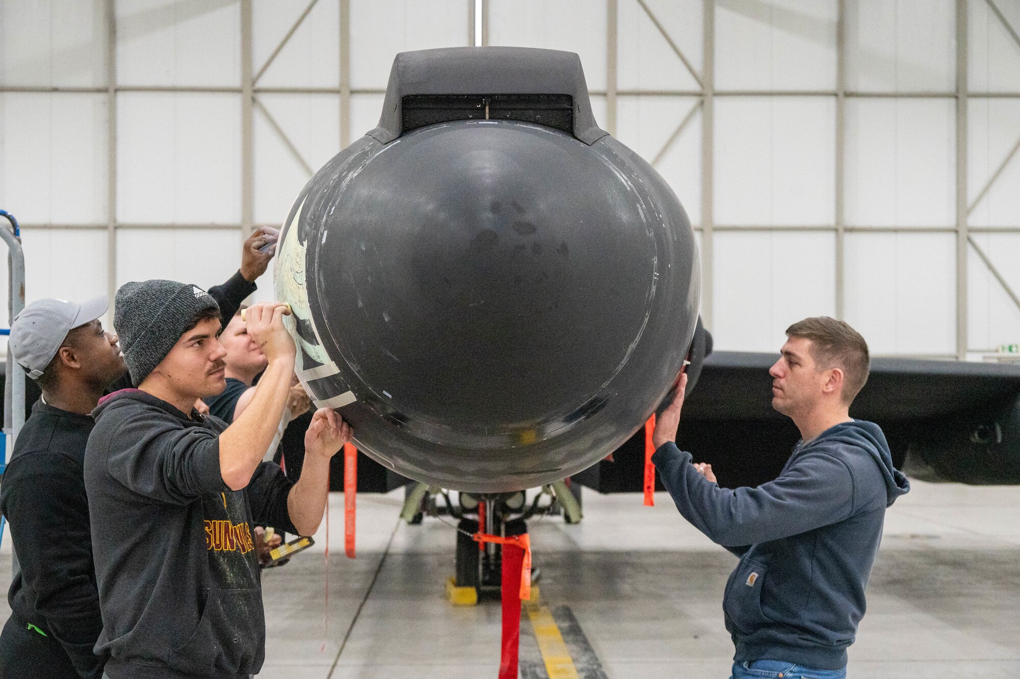 Members of the 99th Expeditionary Reconnaissance Squadron participate in a memorial drawing on a U-2 Dragon Lady.