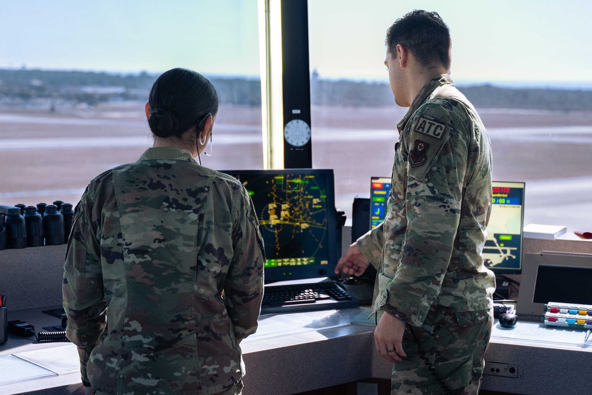 U.S. Air Force Airman 1st Class Shelyann Ortiz-Nevárez, left, and Airman 1st Class Samuel Lazano, right, 1st Special Operations Support Squadron air traffic control journeymen, examine a radar display in the air traffic control tower at Hurlburt Field, Florida, Jan. 30, 2024.