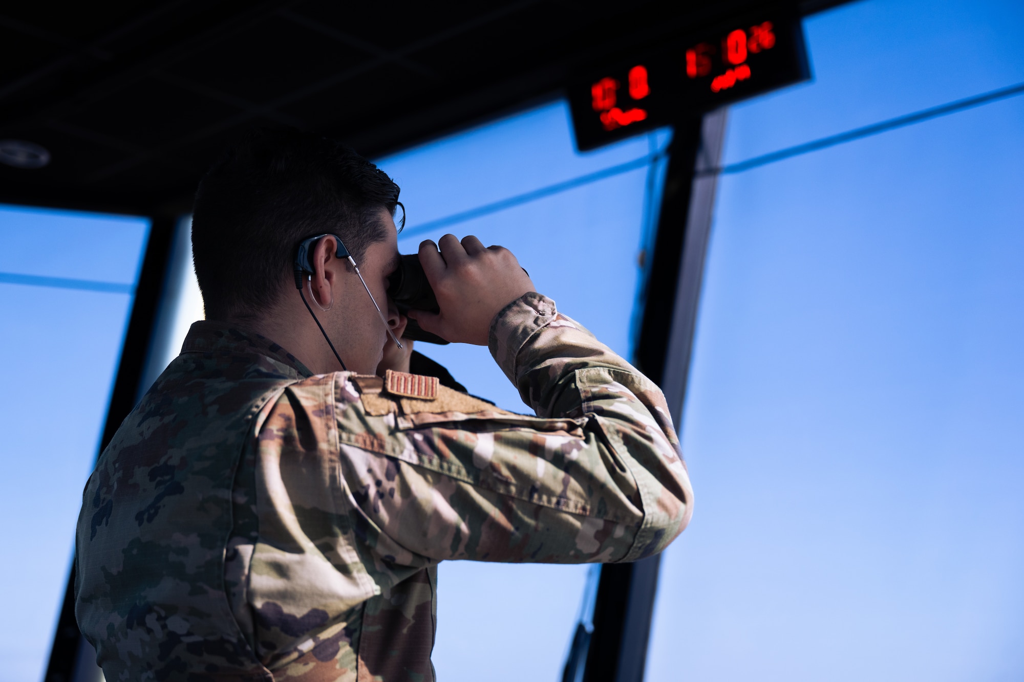 U.S. Air Force Airman 1st Class Samuel Lazano, a 1st Special Operations Support Squadron air traffic control journeyman, looks through a set of binoculars in the air traffic control tower at Hurlburt Field, Florida, Jan. 30, 2024.