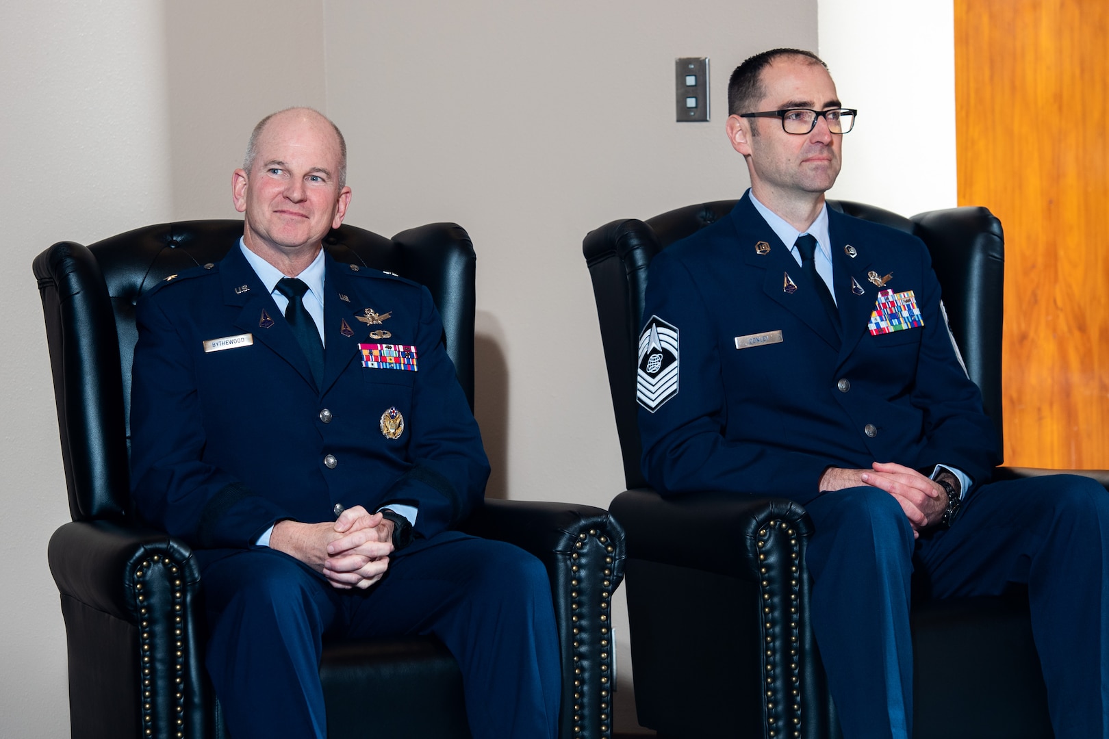 two service members sit next to each other in chairs