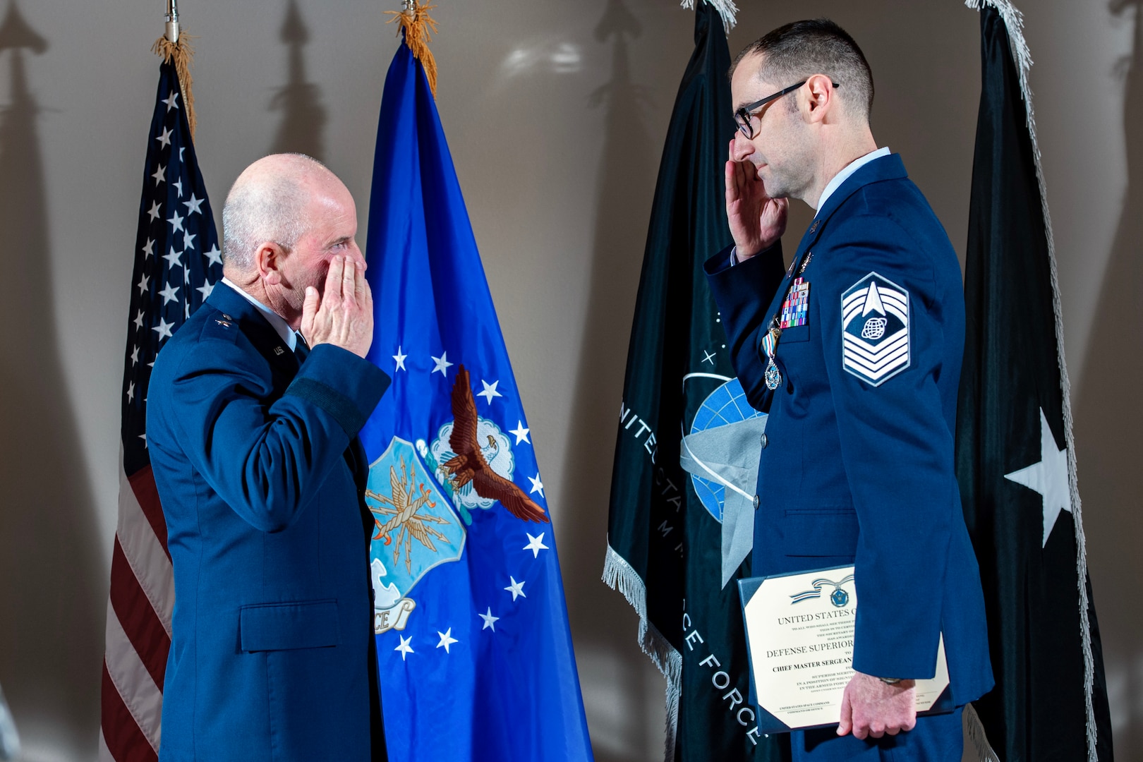 two service members salute each other