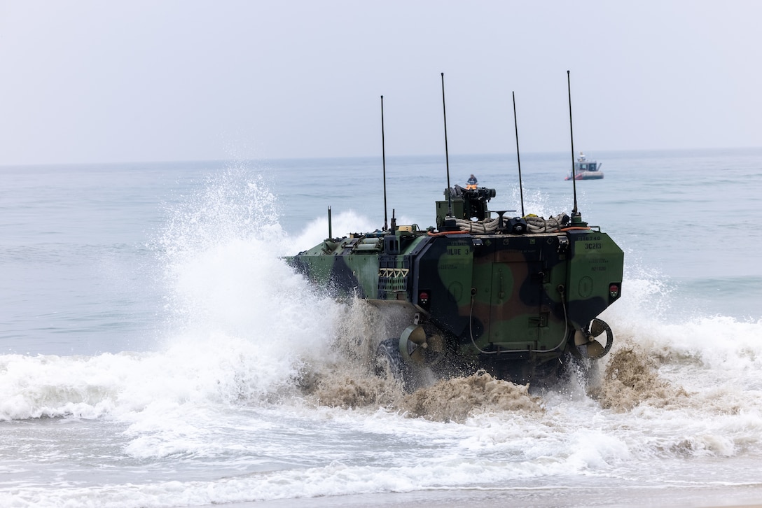 U.S. Marines assigned to Alpha Company, Battalion Landing Team 1/5, 15th Marine Expeditionary Unit, operate an Amphibious Combat Vehicle through the surf zone for an amphibious raid during Realistic Urban Training exercise at Marine Corps Base Camp Pendleton, California, Aug. 25, 2023. RUT is a shore-based, MEU-level exercise that provides an opportunity to train and execute operations as a Marine Air-Ground Task Force in urban environments. (U.S. Marine Corps photo by Lance Cpl. Kahle)