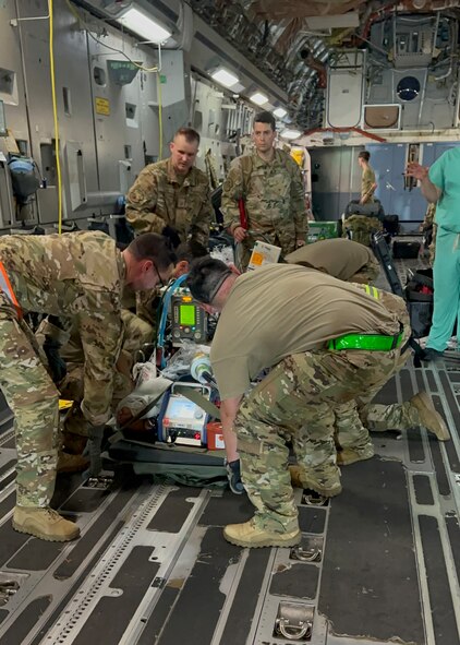 Medics from the 59th Medical Wing’s and Brooke Army Medical Center's Extracorporeal Membrane Oxygenation and Critical Care Air Transport Teams prepare to lift one of two patients in a C-17 Globemaster III to transport them to Brooke Army Medical Center, Joint Base San Antonio-Fort Sam Houston, Texas, Oct. 24, 2023. This is the first air transport of dual-patients on ECMO simultaneously in the Department of Defense’s history. (Courtesy photo by the medical team)