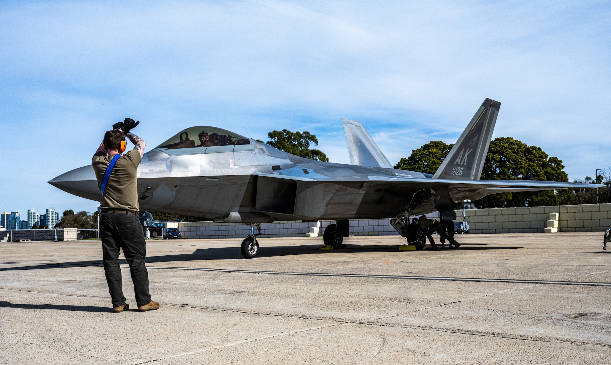 A U.S. Air Force crew chief deployed with the 525th Expeditionary Fighter Generation Squadron, 3rd Air Expeditionary Wing, Joint Base Elmendorf-Richardson, Alaska, marshals an F-22 Raptor during Exercise Bamboo Eagle 24-1 at Naval Air Station North Island, California, Jan. 28, 2024.