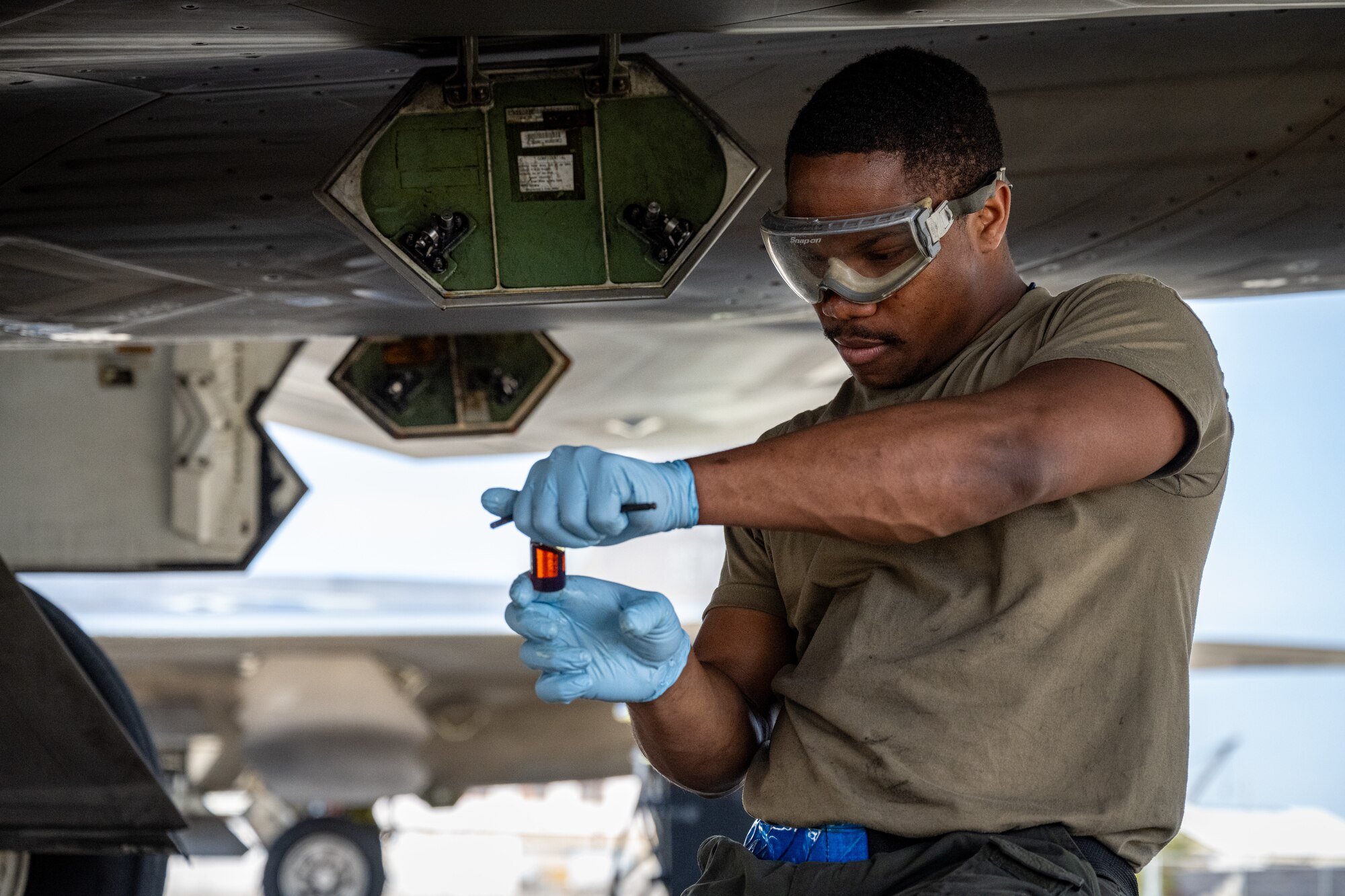 U.S. Air Force Senior Airman Lucien Anderson, a dedicated crew chief deployed with the 525th Expeditionary Fighter Generation Squadron, 3rd Air Expeditionary Wing, Joint Base Elmendorf-Richardson, Alaska, takes an oil sample from an F-22 Raptor during Exercise Bamboo Eagle 24-1 at Naval Air Station North Island, California, Jan. 28, 2024.