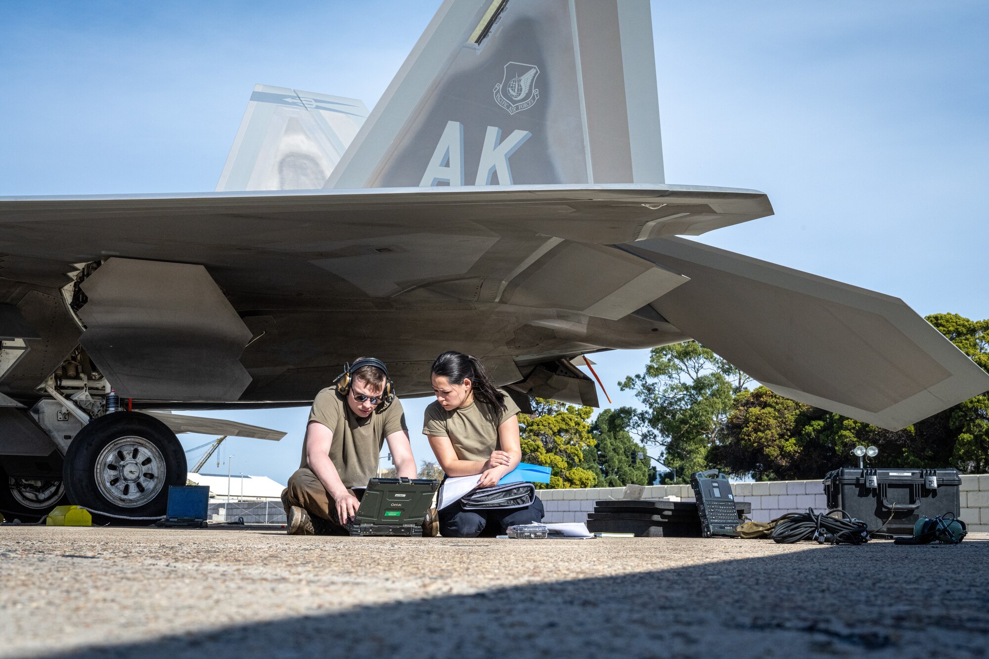 U.S. Air Force Senior Airman Jared Garich (left), an F-22 Raptor dedicated crew chief, and U.S. Air Force Senior Airman Sophia Canelas, an F-22 Raptor avionics specialist, both deployed with the 525th Expeditionary Fighter Generation Squadron, 3rd Air Expeditionary Wing, Joint Base Elmendorf-Richardson, Alaska, prepare a post-flight debrief during Exercise Bamboo Eagle 24-1 at Naval Air Station North Island, California, Jan. 28, 2024.