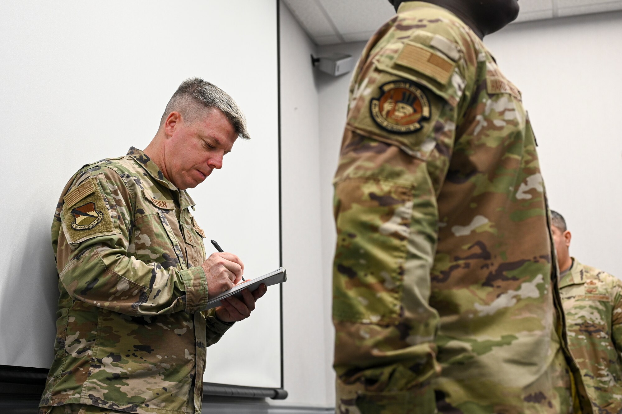 Airman marks a check list during a uniform inspection.