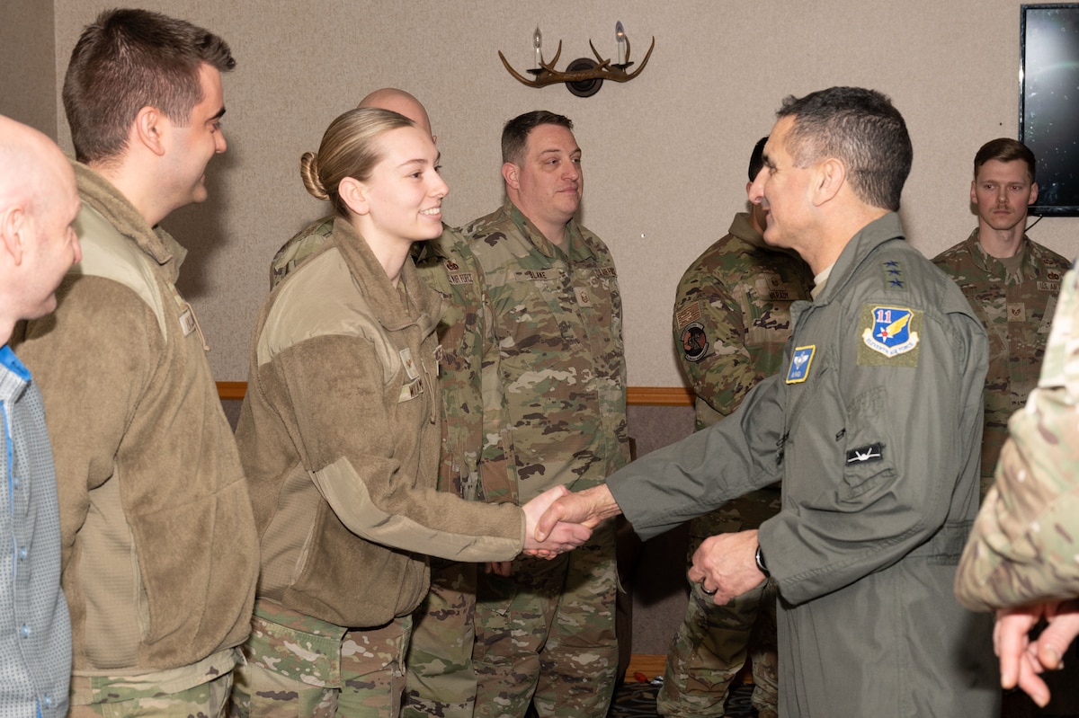 U.S. Air Force Lt. Gen. David Nahom, commander, Alaskan NORAD Region, Alaskan Command and Eleventh Air Force, gives a coin to Senior Airman Emily Williams, 354th Communications Squadron cybersecurity technician, during a base visit at Eielson Air Force Base, Alaska, Feb. 1, 2024.
