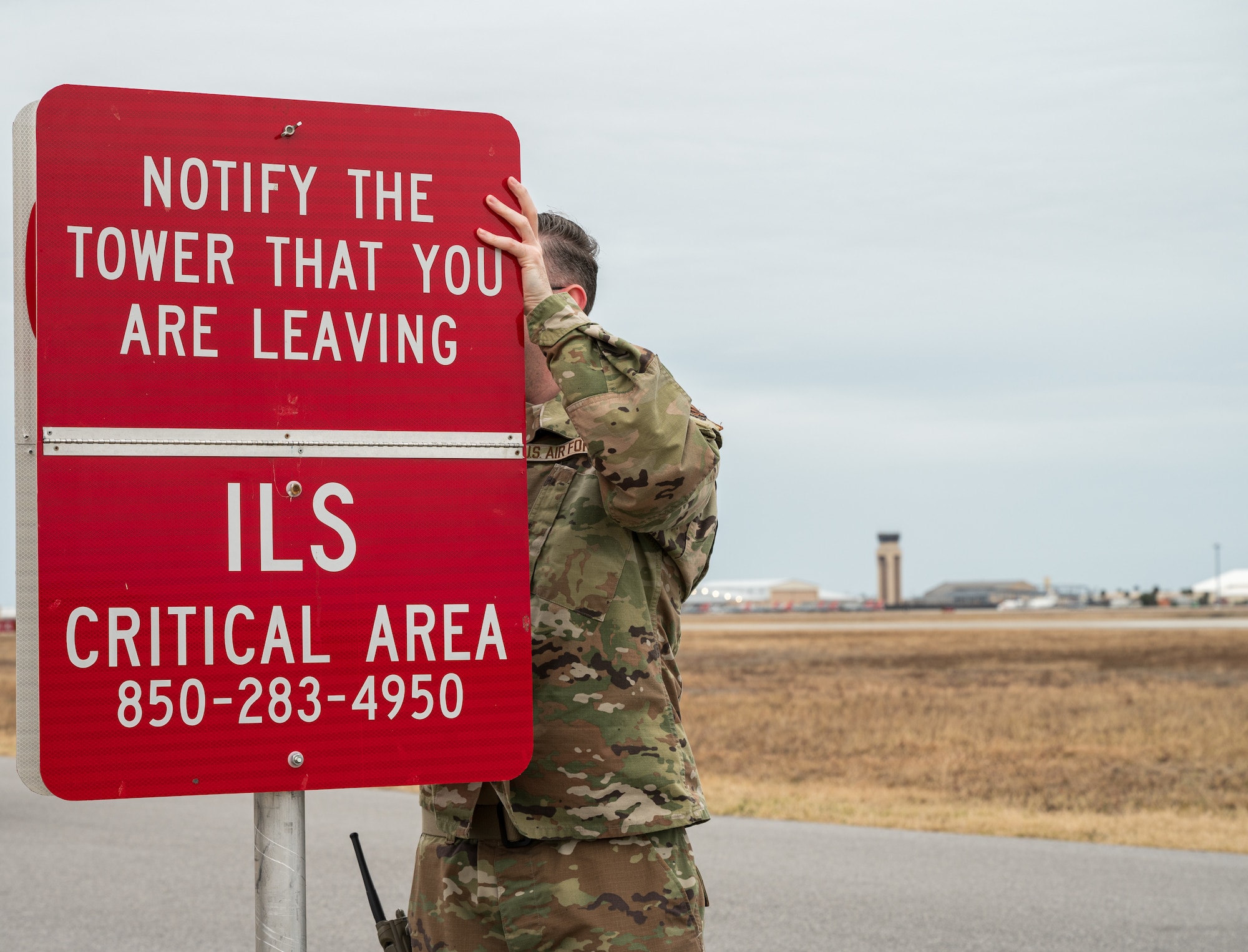 An airmen changes a sign