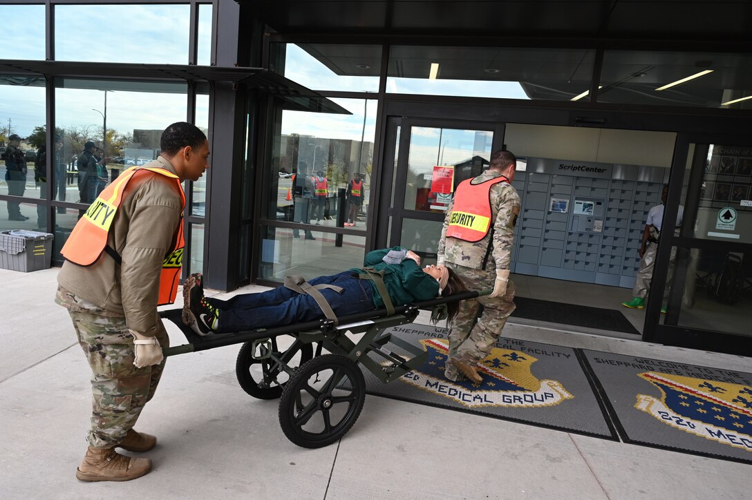 A test patient on a stretcher is rolled into the clinic.