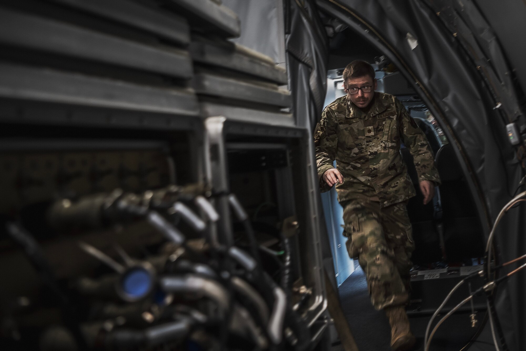 U.S. Air Force Maj. Sean Thal, 134th Air Control Squadron air battle manager, rushes through a KC-46A Pegasus from the 2nd Air Refueling Squadron to configure a Roll-on Beyond Line-of-Sight Enhancement kit during Bamboo Eagle 24-1 at Travis Air Force Base, Calif., Jan. 27, 2024. A ROBE is a self-contained communications suite that advances access to user gateways more efficiently to further combat effectiveness. (U.S. Air Force photo by Staff Sgt. Austin Knox)
