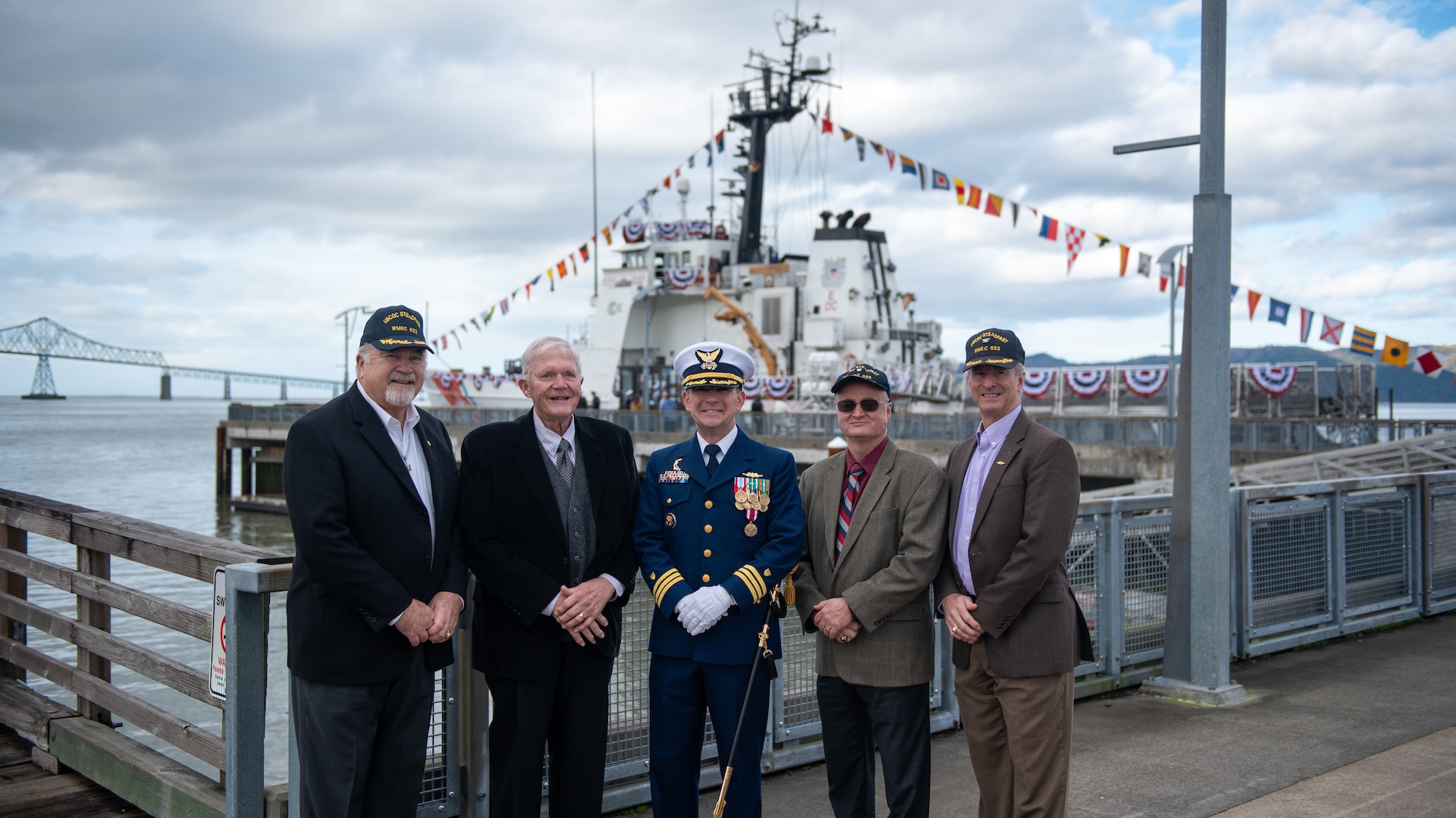 The USCGC Steadfast’s (WMEC 623) prior commanding officers stand before the decommissioned cutter in Astoria, Ore., February 2, 2024. From left to right in the photo is Robert Wicklund, Charles Murray, Cmdr. Brock Eckel, Dr. R.B. Watts and Matt Gimple. (U.S. Coast Guard photo by Petty Officer 3rd class William Kirk)