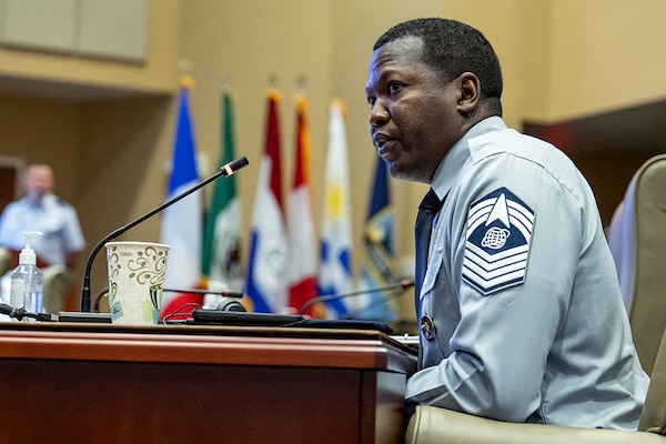 A man in military uniform sits at a table.